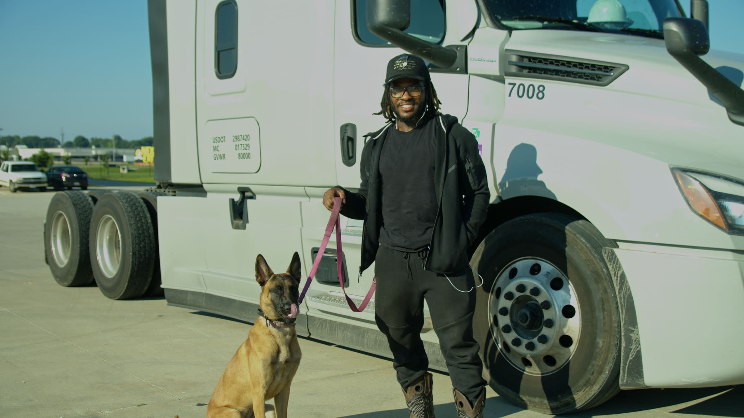 An Onyx Logistics driver with his dog in front of his truck